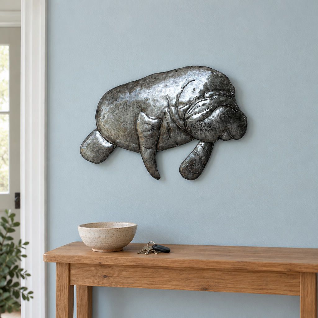 Haitian recycled steel manatee wall art above an oak entryway console