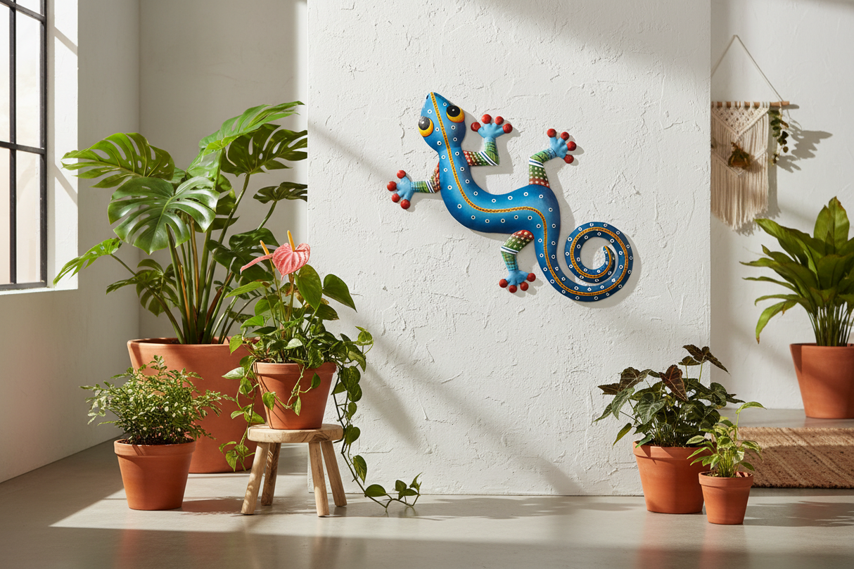 Haitian hand-painted blue metal gecko wall art mounted on white plaster wall with tropical plants