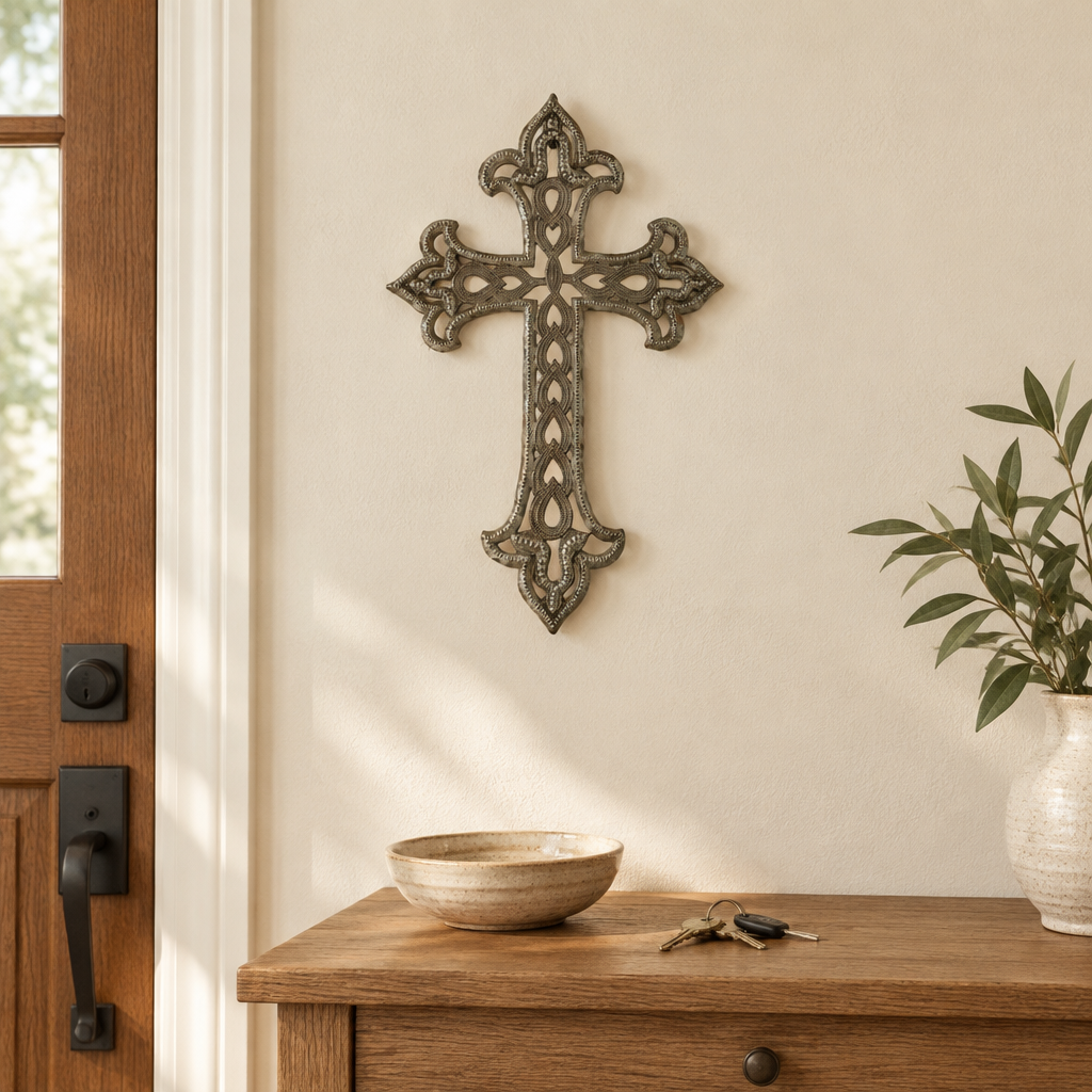 Ornate Haitian steel drum metal cross above an oak entryway console