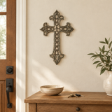 Ornate Haitian steel drum metal cross above an oak entryway console