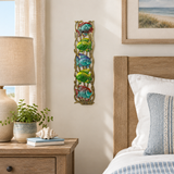Handpainted Haitian stacked tropical fish metal wall art in a coastal guest bedroom