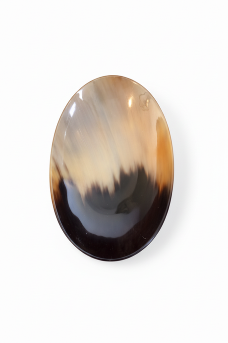 Handmade Haitian oval ivory and black ox horn dish on white background