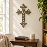 Ornate Haitian metal wall cross in a quiet prayer nook