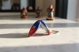 Both sides of Haiti Chérie oval keychain displayed on marble surface – lifestyle photo
