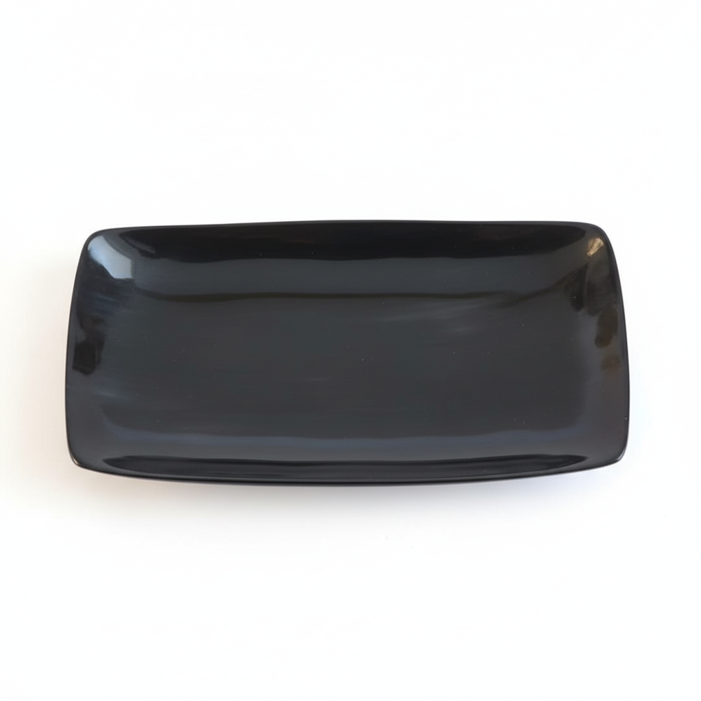 Handmade Haitian black ox horn serving tray with deep ebony gloss finish on white background
