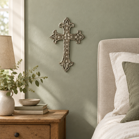 Ornate Haitian metal wall cross beside a bedroom nightstand