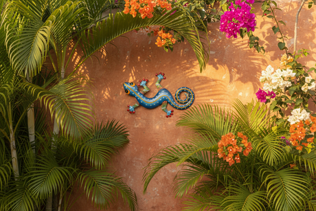 Blue metal gecko wall art on tropical outdoor patio wall