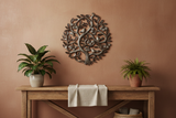 Haitian Tree of Life round metal wall art mounted above a rustic wooden console in a warm-toned living room
