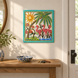 Handpainted Haitian flamingo and palm tree metal wall art above an entryway console