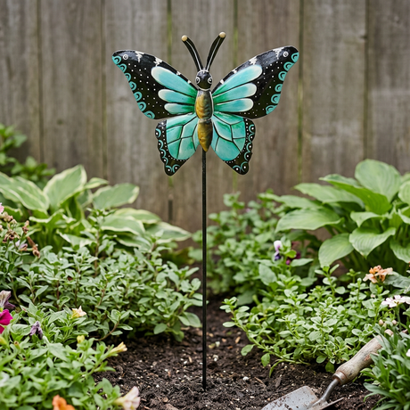Turquoise and black butterfly garden stake near a wooden fence