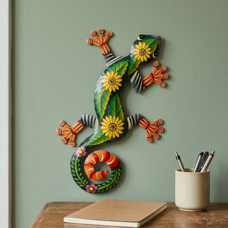 Handmade steel drum lizard with yellow sunflowers beside a wooden office desk