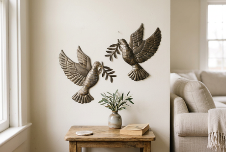 Dove with Olive Branch metal wall art set above a living room side table