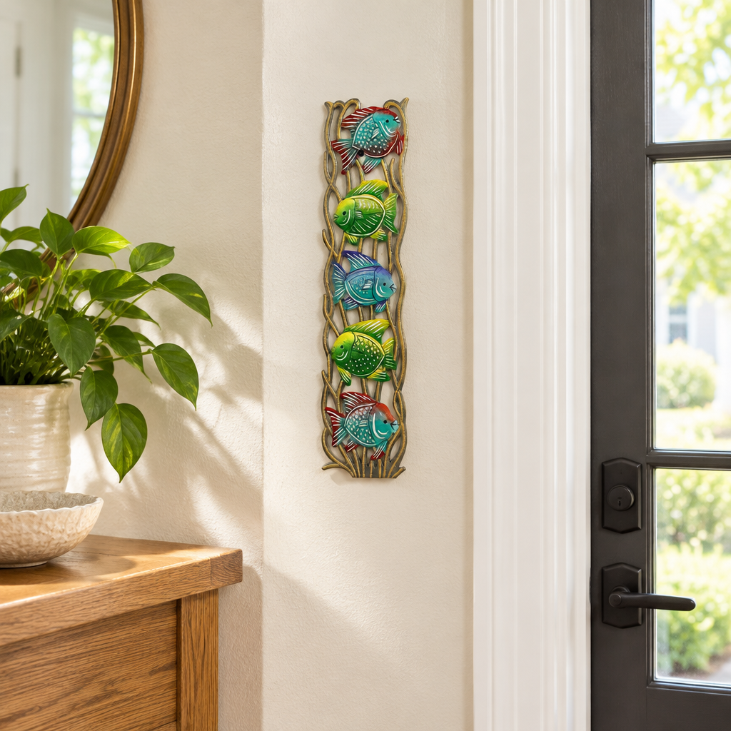 Handpainted Haitian stacked tropical fish metal wall art beside an entryway doorway