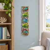 Handpainted Haitian stacked tropical fish metal wall art beside a living room bookshelf