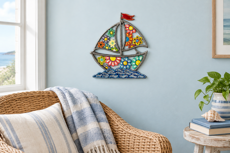 Colorful daisy sailboat metal wall art in a coastal reading nook