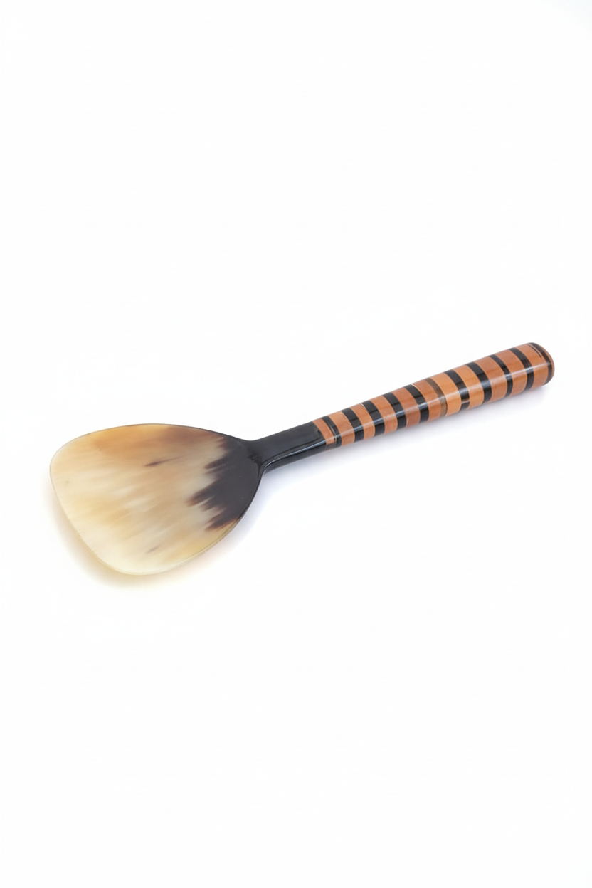 Handmade Haitian ivory ox horn and striped wood rice paddle spatula on white background