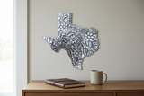 Silver-toned Texas floral steel drum wall art above a home office desk