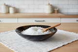 Haitian black horn bowl holding sea salt with wooden spoon on white linen Scandinavian kitchen