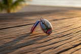 Both sides of Haiti double-sided keychain displayed on rustic wood – lifestyle photo