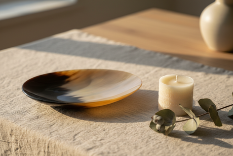 Haitian ivory horn dish with candle and eucalyptus on neutral linen in Scandinavian interior