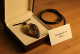 Haitian horn pendant necklace in luxury cream velvet gift box beside handmade in Haiti card