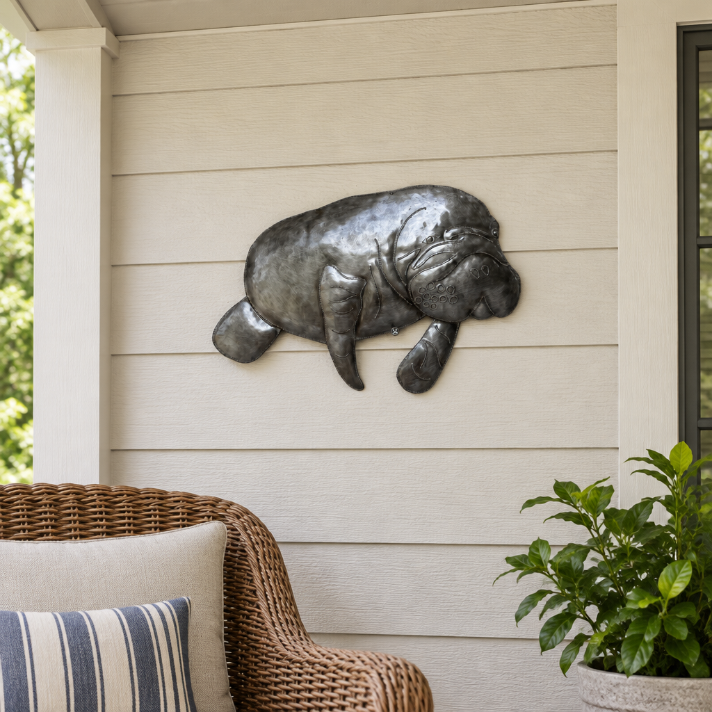 Haitian recycled steel manatee wall art on a sheltered covered porch