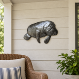 Haitian recycled steel manatee wall art on a sheltered covered porch