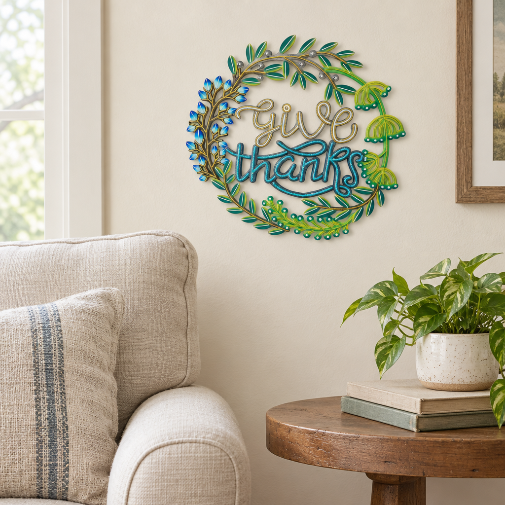 Handpainted Haitian Give Thanks metal wall art beside a living room armchair