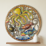 Yellow octopus, colorful fish, and wave details in hand-chiseled steel drum wall art.