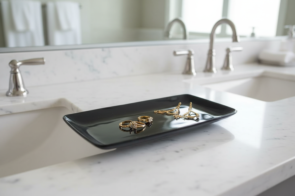 Haitian black ox horn tray holding gold jewelry on white marble vanity