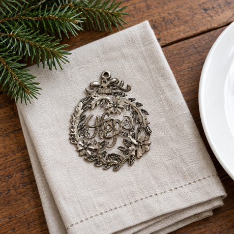 Handmade Haitian Hope metal Christmas ornament on a holiday table setting
