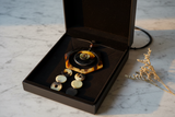 Haitian horn hexagon disc cascade necklace in luxury black velvet gift box with dried flowers on marble