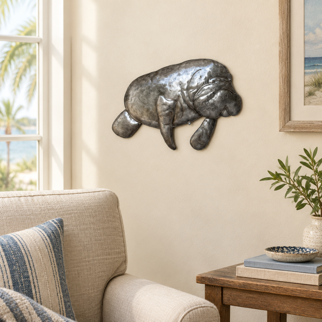 Haitian recycled steel manatee wall art beside a living room armchair