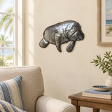 Haitian recycled steel manatee wall art beside a living room armchair