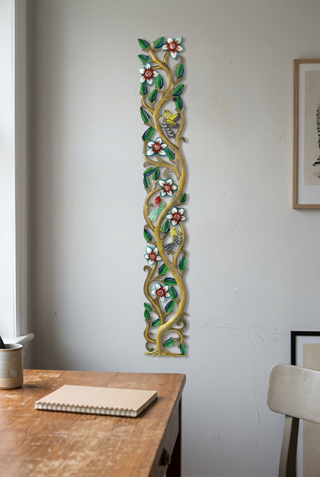 Colorful handmade metal tree wall sculpture beside a wooden office desk