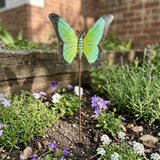 Light green and yellow steel butterfly garden stake in a flower bed