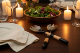 Haitian striped horn salad fork beside matching spoon on luxury dining table with salad bowl by candlelight