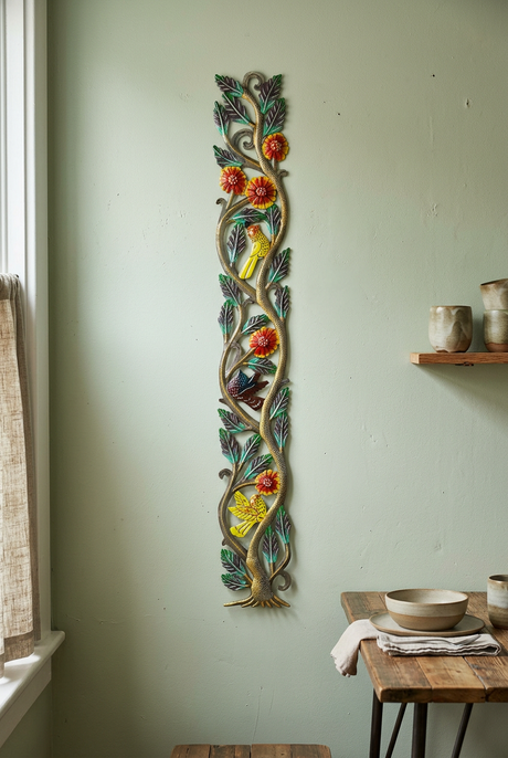 Hand-hammered tree metal wall art with birds and flowers on a sage dining room wall.