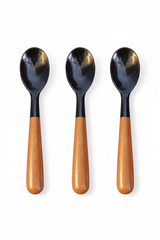 Handmade Haitian black ox horn and teak wood serving spoon on white background