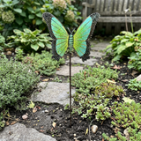 Green and yellow metal butterfly stake beside a stone garden path