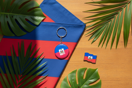 Haiti flag keychain flat lay with tropical leaves and Caribbean styling