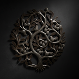 Close-up detail of Haitian Tree of Life metal art with dramatic side lighting on a dark background