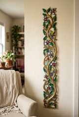 Tall Haitian steel drum tree with birds and flowers beside a linen armchair